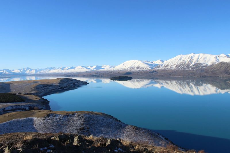 Snow covered mountains next to a lake